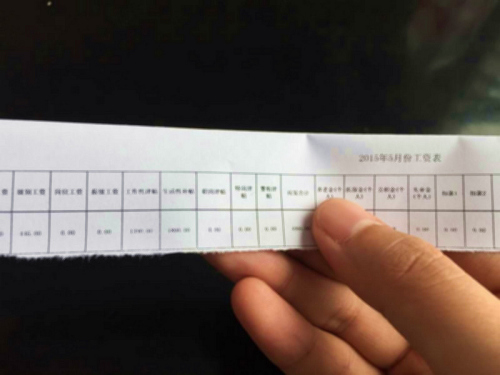 某基层公务员在看工资条(网友供图)