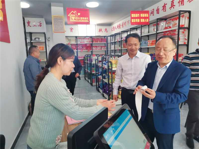 石超刚主任在邵阳县梅溪村集中安置点爱心超市查看积分兑换商品单